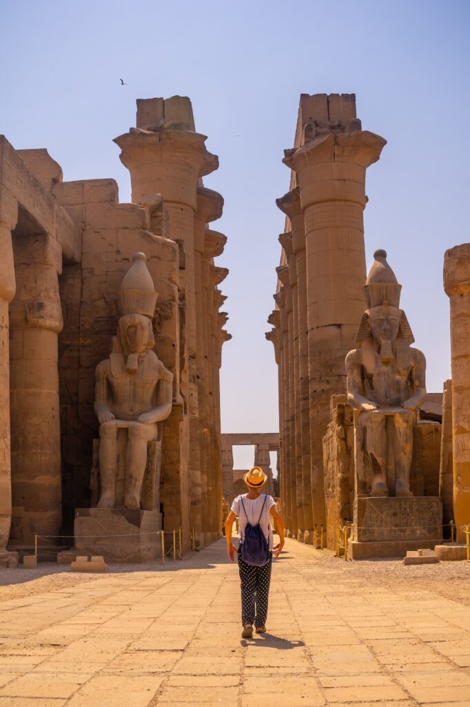 Woman with a hat visiting the Egyptian Temple of Luxor and its beautiful columns. Egypt